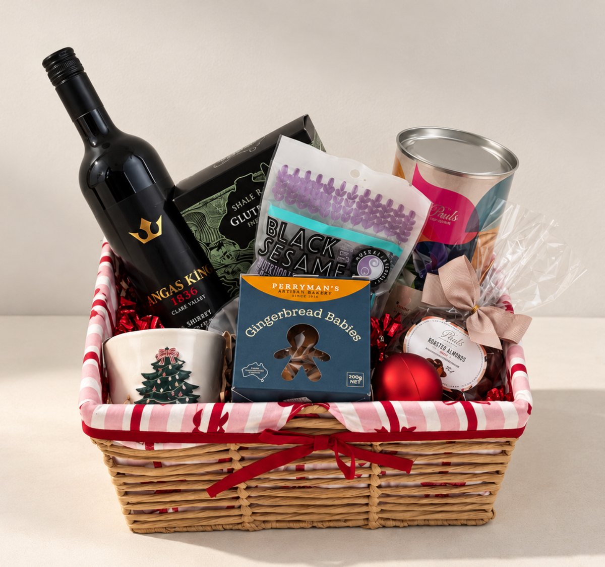 Hamp It Up x Kemeny’s Angas King Shiraz Christmas hamper with Clare Valley Shiraz, Paul’s chocolates, Perryman’s gingerbread babies, crackers and Christmas tree candle in a striped woven basket