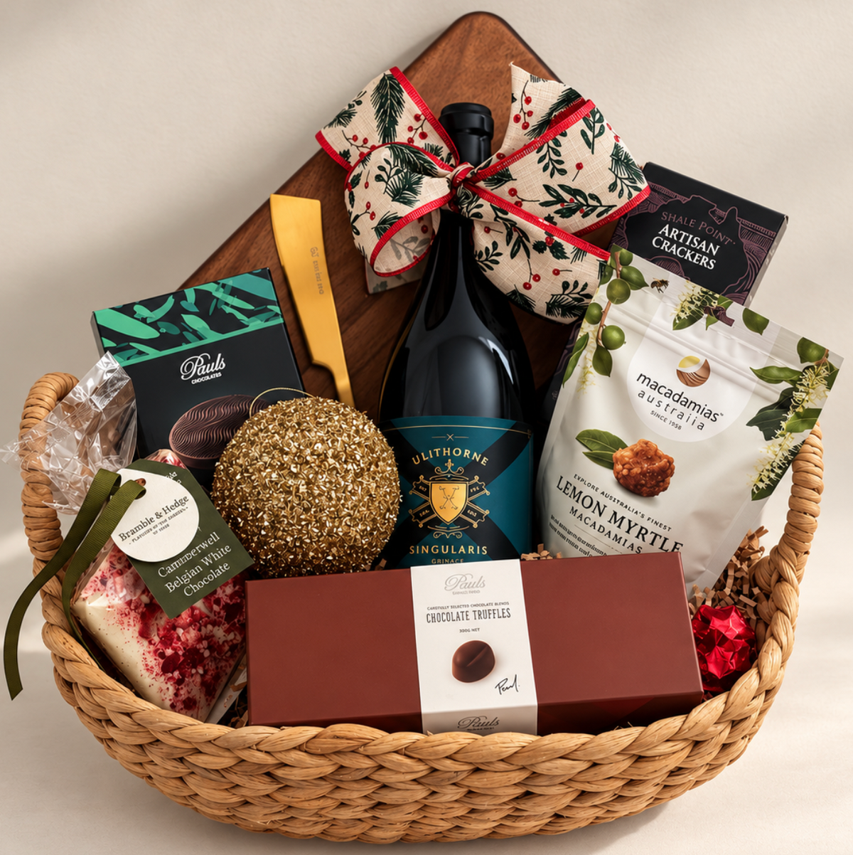 Hamp It Up x Kemeny’s Ultra Luxe Christmas hamper with Ulithorne Singularis Grenache, wooden serving board, gold cheese knife, artisan crackers, lemon myrtle macadamias and Paul’s chocolate truffles in a woven basket