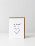 See Aiche greeting card reading “I’m obsessed with you.” above a hand-drawn heart outlined several times, with a kraft envelope