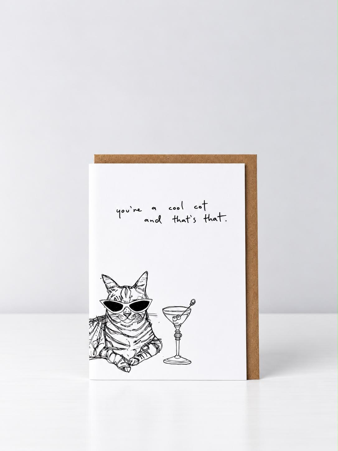 You’re a Cool Cat greeting card with a hand-drawn tabby cat in cat-eye sunglasses beside a martini, with a kraft envelope